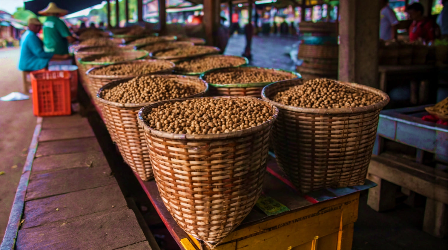 Traditional Amazon market scene showing large woven baskets filled with açaí beans, highlighting the raw ingredient used by Tupan Beverages, sourced from the Amazon region and connected to sustainable harvesting, local communities, and the transformation of açaí beans into premium functional beverages.