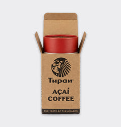 Tupan Açaí Coffee tube placed inside an open kraft box, front view on white background, sustainable Amazonian beverage made from roasted açaí beans.