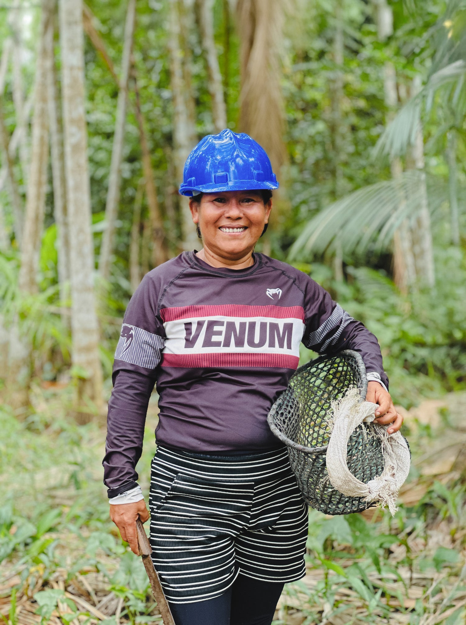 Iranildes Braga, harvester at the Amazonbai cooperative, smiling in the heart of the Amazon rainforest after collecting fresh açaí beans.